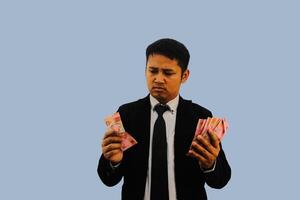 adulto asiatico uomo confuso per scegliere il suo i soldi per shopping foto