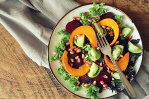 salutare vegetariano insalata, arrostito zucca, pomodoro, melograno, cavolo, barbabietola foto