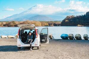 donna turista godere con fuji montagna a lago shoji, contento viaggiatore giro turistico montare fuji e strada viaggio fuji cinque laghi. punto di riferimento per turisti attrazione. Giappone viaggiare, destinazione e vacanza foto