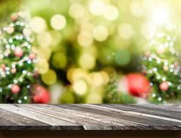 piano del tavolo in legno diagonale con sfocatura astratta dello sfondo dell'albero di Natale foto