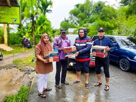 pariama, Indonesia - marzo 8, 2024. Sig. regionale segretario di pariama città mani al di sopra di cibo aiuto per alluvione vittime nel nord pariama quartiere foto