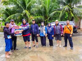 pariama, Indonesia - marzo 8, 2024. Sig. regionale segretario di pariama città mani al di sopra di cibo aiuto per alluvione vittime nel nord pariama quartiere foto