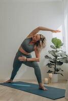 un' 50 anni donna fa yoga a casa foto