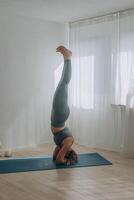 un' 50 anni donna fa yoga a casa foto