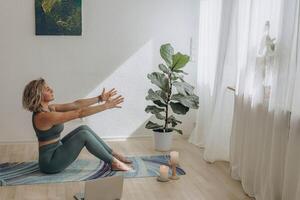 un' 50 anni donna fa yoga a casa foto