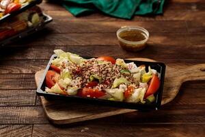 qunioa insalata con fagioli, pomodoro, cetriolo e salsa servito nel un' piatto isolato su di legno tavolo sfondo lato Visualizza di insalata foto