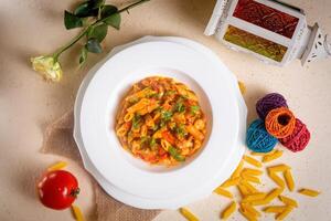 speziato penne masala pasta ritirare pomodoro nel un' ciotola isolato su sfondo lato Visualizza foto