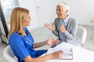 anziano donna, medico e anziano paziente con bene notizia, tavoletta e risultati per Salute, consigli e rapporto. contento medico, appunti con Sorridi, Tech o supporto nel ospedale foto