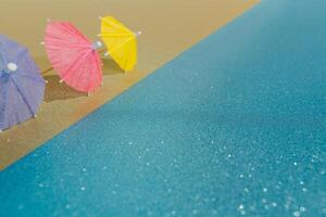 astratto spiaggia con luccichio carta sabbia e acqua e cocktail ombrelli foto
