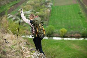 giovane donna con zaino escursioni a piedi nel il montagne. escursioni a piedi concetto. il trekking scogliere. viaggiare, viaggiatore. foto