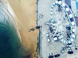aereo Visualizza di un' Ferris ruota vicino il spiaggia su un' soleggiato giorno nel cascais, Portogallo foto