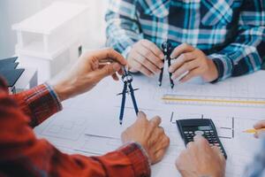 ingegnere persone incontro Lavorando e puntamento a un' disegni nel ufficio per discutere. ingegneria utensili e costruzione concetto. foto