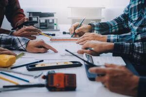 ingegnere persone incontro Lavorando e puntamento a un' disegni nel ufficio per discutere. ingegneria utensili e costruzione concetto. foto