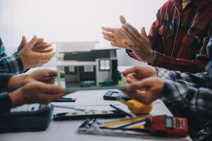 ingegnere persone incontro Lavorando e puntamento a un' disegni nel ufficio per discutere. ingegneria utensili e costruzione concetto. foto