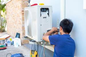 maschio tecnico installazione all'aperto unità di aria condizionatore per freddo il domestico nel il estate. aria compressore, elettronico, foto