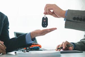 auto commerciante è passaggio al di sopra di auto chiavi per cliente dopo i saldi contrarre e rata contrarre avere stato firmato. concetto di passaggio al di sopra di auto chiavi per i clienti dopo il i saldi contrarre ha stato approvato foto