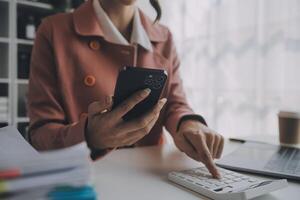 il ritratto di una giovane donna asiatica libera professionista sta lavorando sul tablet del computer in un ufficio moderno. fare un rapporto di analisi contabile dati di investimento immobiliare, concetto di sistemi finanziari e fiscali. foto