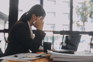 asiatico donne siamo stressato mentre Lavorando su computer portatile, stanco asiatico donna d'affari con mal di testa a ufficio, sensazione malato a opera, copia spazio foto