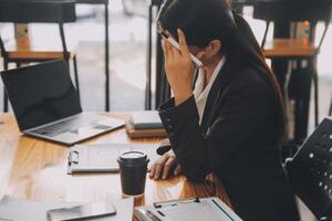 asiatico donne siamo stressato mentre Lavorando su computer portatile, stanco asiatico donna d'affari con mal di testa a ufficio, sensazione malato a opera, copia spazio foto