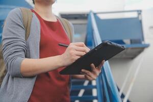 bionda femmina turista controllo arrivo notifica su smartphone seduta su posto a sedere di aereo con netbook.young donna d'affari Condividere media a partire dal telefono su il computer portatile computer durante aereo volo foto