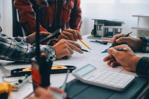 ingegnere persone incontro Lavorando e puntamento a un' disegni nel ufficio per discutere. ingegneria utensili e costruzione concetto. foto