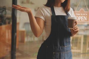 avvio di successo della piccola impresa titolare sme bellezza ragazza stand con tablet smartphone nel ristorante caffetteria. ritratto di donna asiatica abbronzata barista barista proprietario. concetto di business venditore imprenditore PMI foto