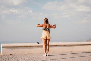 donna estate danza. silhouette di un' contento donna chi balli, gira e solleva sua mani per il cielo. un' giocoso giovane donna gode sua contento momento danza nel il raggi di il d'oro sole. foto