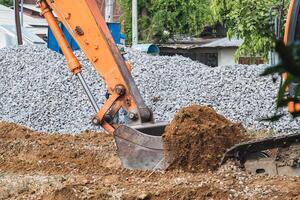 scavatrice scavando suolo e pietra su costruzione luogo foto