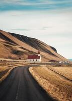 reynisfjara luterano Chiesa con il strada su il modo per reynisfjara spiaggia nel autunno a vik, Islanda foto