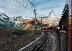 Visualizza di Cervino montagna e il treno cavalcata su per stazione nel autunno a Zermatt foto