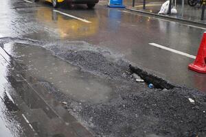 grande pentola buco pieno con acqua a strada foto