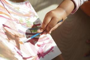 bambina che disegna su carta seduta sul pavimento foto