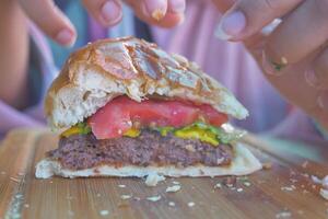 metà mangiato Manzo hamburger su tavolo vicino su foto