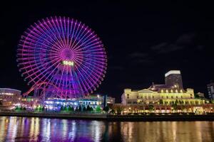 un' notte illuminato Ferris ruota nel Yokohama largo tiro foto