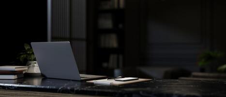un' avvicinamento Immagine di un' il computer portatile computer su un' buio marmo scrivania nel un' moderno buio ufficio. foto