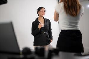 attraente asiatico femmina modello è in posa per un' fotografo, Lavorando nel un' moda servizio fotografico studio. foto