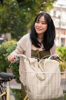 un' donna andando per un' supermercato con sua bicicletta. un' femmina viaggiatore esplorando il città con un' bicicletta. foto