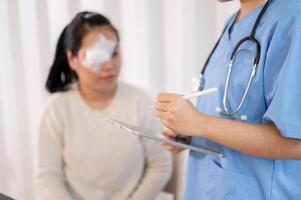 un' medico o infermiera utilizzando un' digitale tavoletta mentre chiede di un' del paziente sintomi nel il ufficio. foto