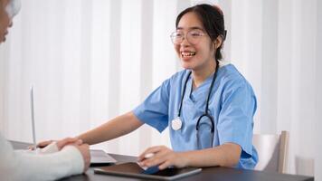 un' professionale asiatico femmina medico è Lavorando nel sua ufficio, parlando e dando consigli per un' paziente. foto