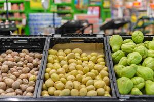 In piedi di patate e chayote nel un' supermercato. foto