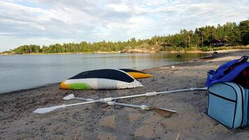 Due giallo, bianca e verde canoe posto sottosopra giù su il spiaggia per asciutto dopo un' riga foto