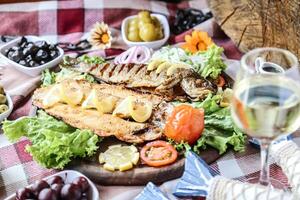 tavolo con piatto di cibo e bicchiere di vino foto