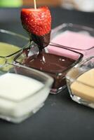 cioccolato coperto fragola essere immerso con un' stuzzicadenti foto