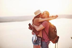 emozioni in alto. la giovane coppia ha deciso di trascorrere le proprie vacanze in modo attivo sul bordo della splendida roccia con il lago sullo sfondo foto