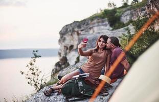 facciamo un selfie. due persone sedute sulla roccia e guardando la natura meravigliosa