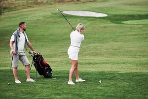 cercando di colpire la palla. un paio di giocatori di golf si divertono durante il fine settimana foto