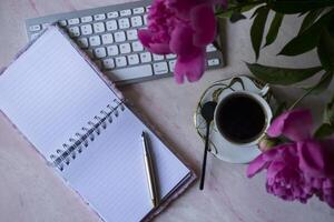 bellissimo posto di lavoro con caffè e peonia. foto