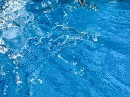 sfondo dinamico spruzzo di chiaro acqua la creazione di vorticoso onda nel blu acqua con goccioline sospeso nel movimento. pulito acqua concetto. foto