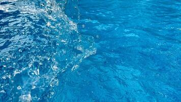 sfondo dinamico spruzzo di chiaro acqua la creazione di vorticoso onda nel blu acqua con goccioline sospeso nel movimento. pulito acqua concetto. foto