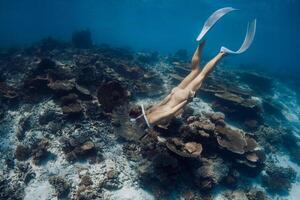 donna apneista immersioni nel blu mare. apneista ragazza nuotate subacqueo nel Hawaii foto